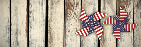 3D image composite of pinwheel with American flag pattern against wood panelling in patternの写真素材