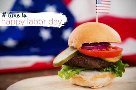 Digital composite image of time to happy labor day text against burger on plate against american flagの写真素材
