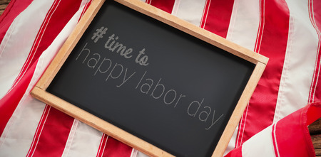 Digital composite image of time to happy labor day text against american flag with slate on wooden tableの写真素材