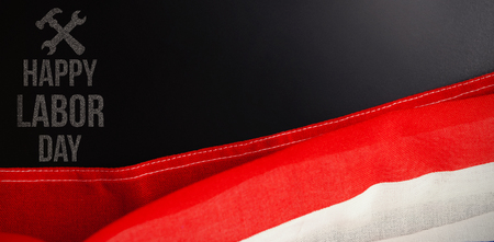 Digital composite image of happy labor day text with tools against american flag and empty slate on wooden tableの写真素材
