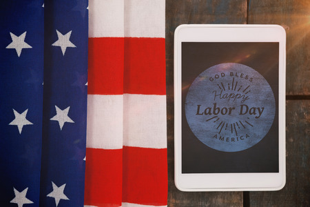 Blurry animated flare against digital tablet by american flag on tableの写真素材