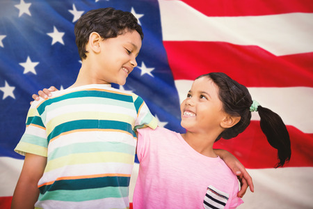 Happy friends against white background against close-up of us flagの写真素材