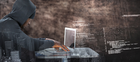 Male hacker using laptop on table  against brown textured backgroundの写真素材