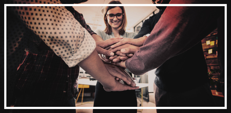 Team of businesspeople forming hand stack in office