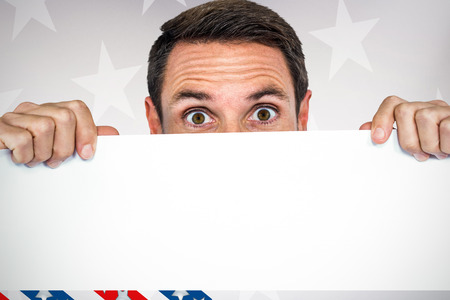 Man holding blank sheet  against digital image of american flagの写真素材