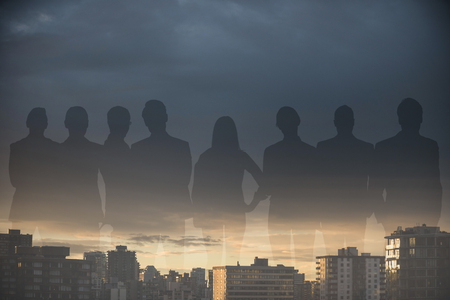 Business people standing over white background against city against cloudy sky during sunsetの写真素材