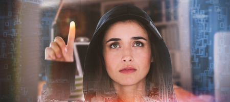 Young female hacker using digital screen against composite image of shiny spiral of binary code