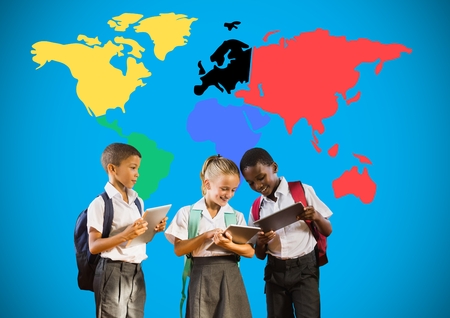 Digital composite of School kids looking at tablets in front of colorful world mapの写真素材