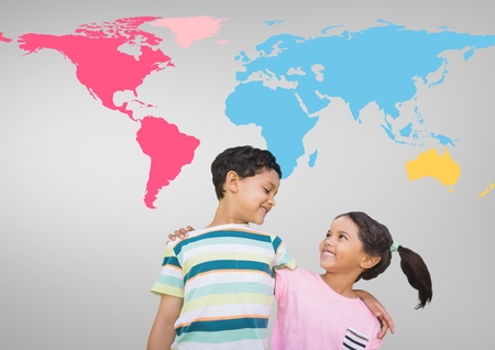 Digital composite of Kids hugging in front of colorful world mapの写真素材