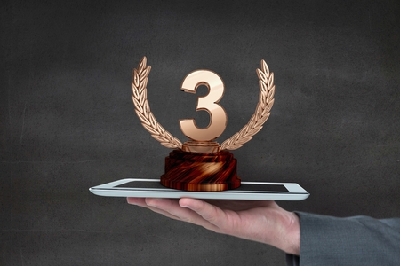 Digital composite of Person holding a tablet with a trophyの写真素材