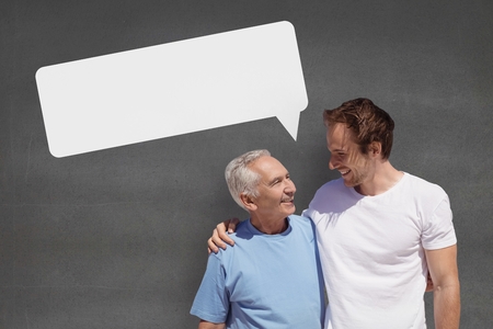 Digital composite of Father and son with speech bubble against grey backgroundの写真素材