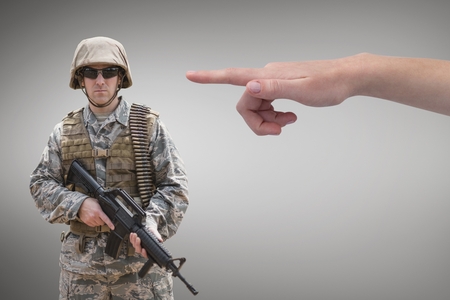 Digital composite of Hand pointing at soldier against grey backgroundの写真素材
