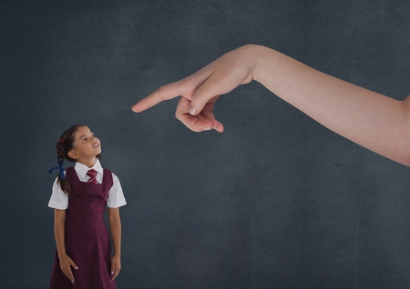 Digital composite of Hand pointing at girl looking up against blue backgroundの写真素材