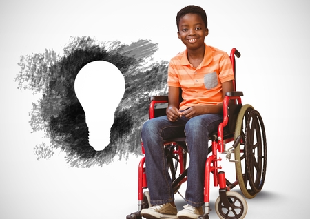 Digital composite of Disabled boy in wheelchair next to charcoal light bulbの写真素材