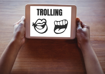 Digital composite of Trolling text and mouth cartoons on tablet in handsの写真素材
