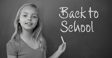 Digital composite of Girl writing Back to school text on blackboardの写真素材