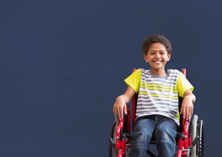 Digital composite of Disabled boy in wheelchair in front of blackboardの写真素材