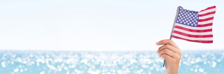 Digital composite of Person holding USA flag against sea backgroundの写真素材