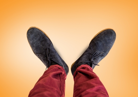 Digital composite of Grey shoes on feet with orange backgroundの写真素材