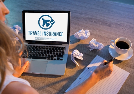 Digital composite of Woman using a computer with travel insurance concept on screenの写真素材