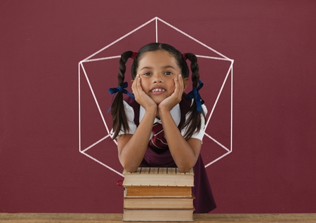Digital composite of Student girl at table against red blackboard with school and education graphicの写真素材