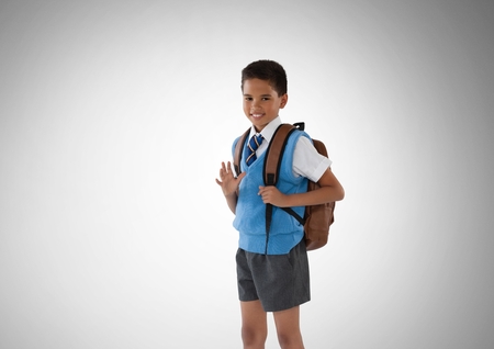 Digital composite of Schoolboy in front of grey backgroundの写真素材