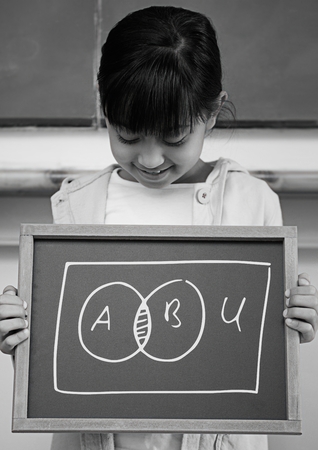 Digital composite of Girl holding blackboard with chart diagramsの写真素材