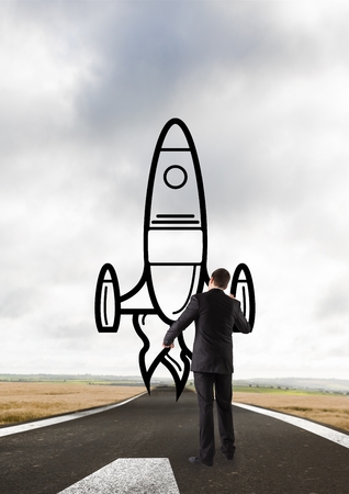 Digital composite of Business man drawing a rocket on the roadの写真素材