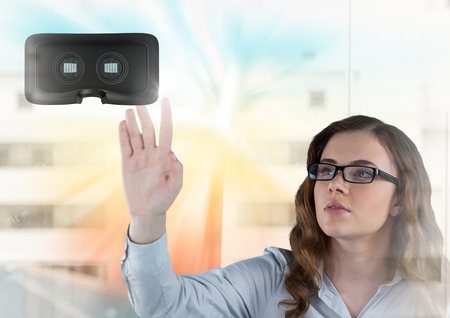 Digital composite of Woman touching and interacting with virtual reality headset with transition...