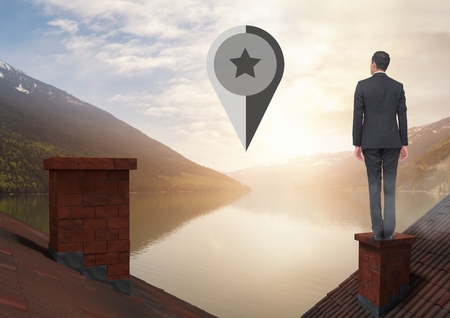 Digital composite of Marker location pointer and Businessman standing on Roofs with chimney and lake mountain landscapeの写真素材