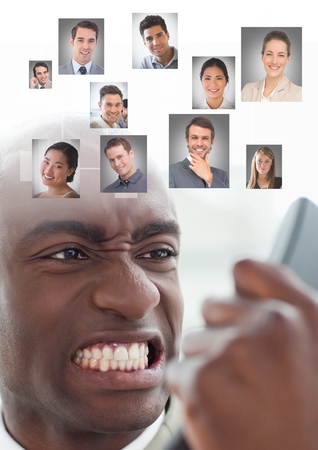 Digital composite of Angry frustrated Man holding phone with Profile portraits of people contactsの写真素材