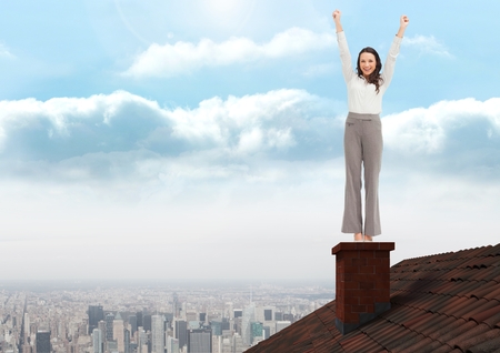 Digital composite of Businesswoman standing on Roof with chimney and cityの写真素材