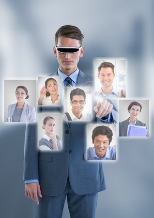 Digital composite of Businessman with Virtual Reality head set interacting and choosing a person from group of people intの写真素材