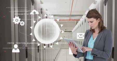 Digital composite of Business woman holding a tablet and graphics in server room