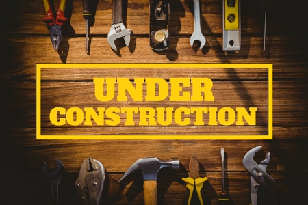 Digital composite of Under construction text against tools photo