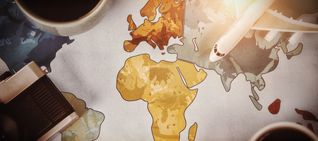 High angle view of coffee with toy airplane and camera on mapの写真素材