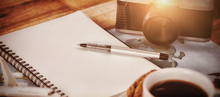 Close up of coffee cup with camera and diary map at tableの写真素材
