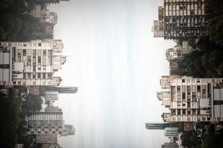 Trees amidst buildings in city against skyの写真素材