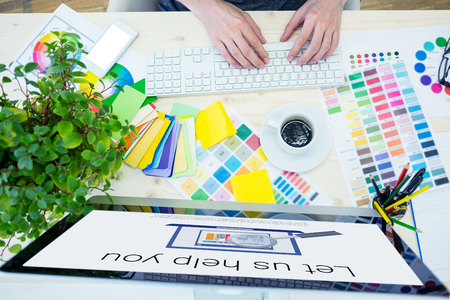 Let us help you text with computer icon against graphic designer working using computer at deskの写真素材