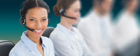 Business people with headsets using computers  against turquoise and orange backgroundの写真素材