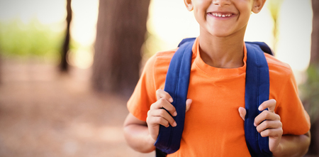 Little boy carrying backpack during a walk in the forestの写真素材