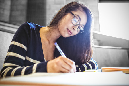 Focused student writing on notebook at university
