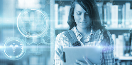 Digital composite image of DNA helix against cute young student using a tablet computerの写真素材