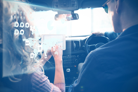Global technology background against couple looking at tablet on a carの写真素材