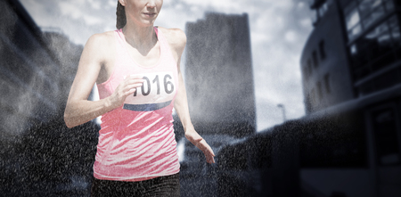 Athletic woman running against white background against digitally composite image of dust powderの写真素材