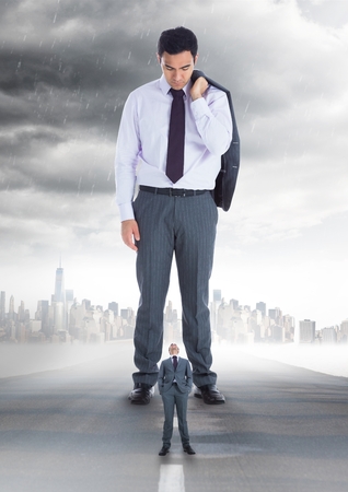 Digital composite of Small business man looking at a big business manの写真素材