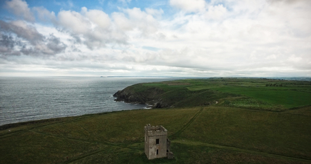 Idyllic view of sea and hill against skyの写真素材