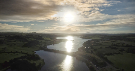Scenic view of river amidst landscape against sky during sunsetの写真素材