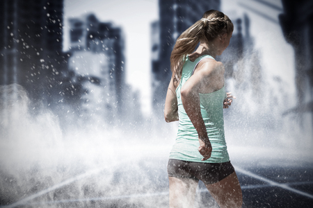 Rear view of sportswoman running on a white background against splashing of white dust powderの写真素材