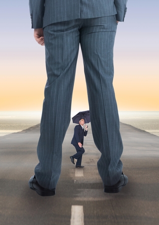 Digital composite of Scared small business man looking at a big business manの写真素材
